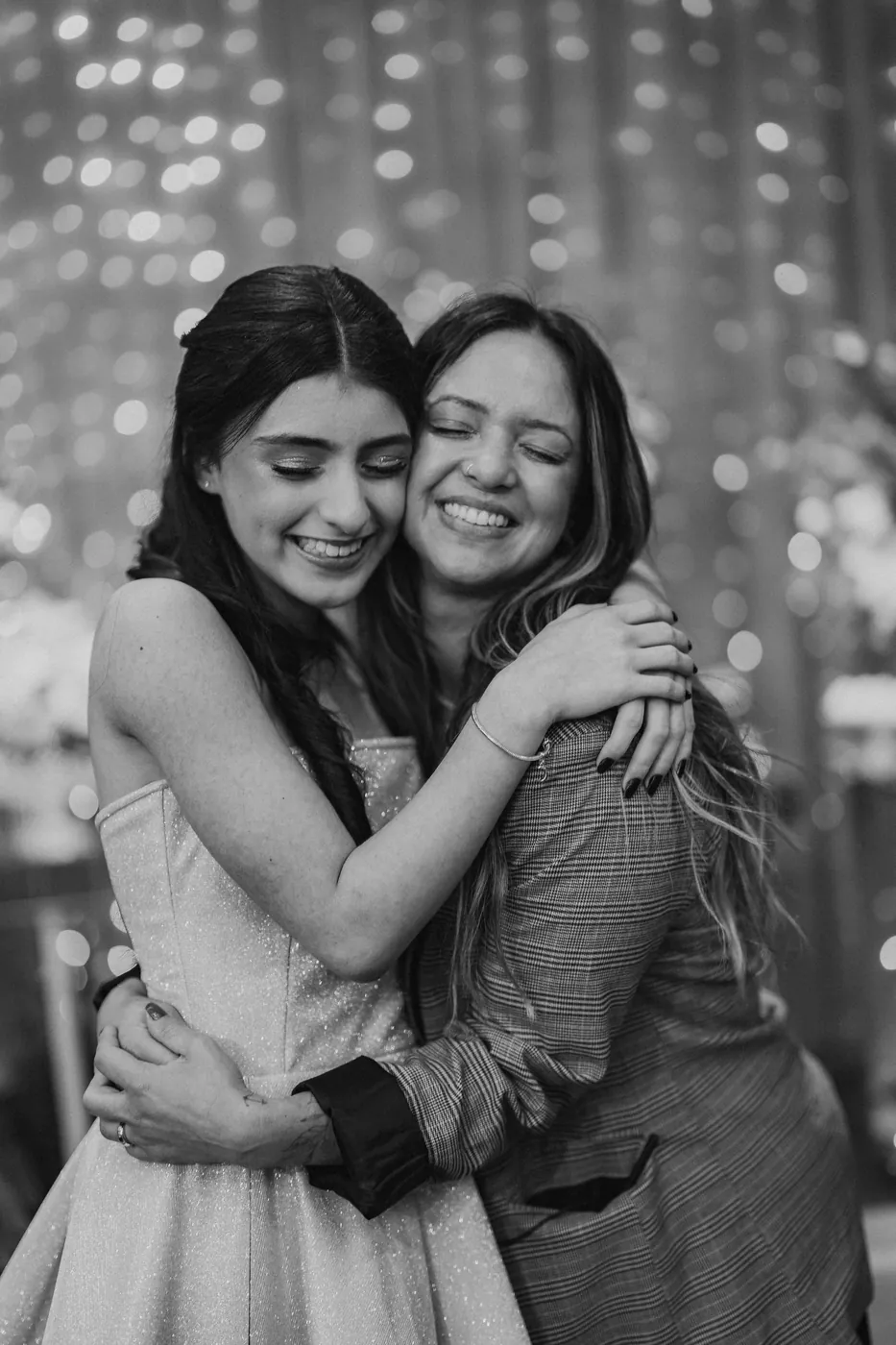 Camila abraçando a debutante, em preto e branco